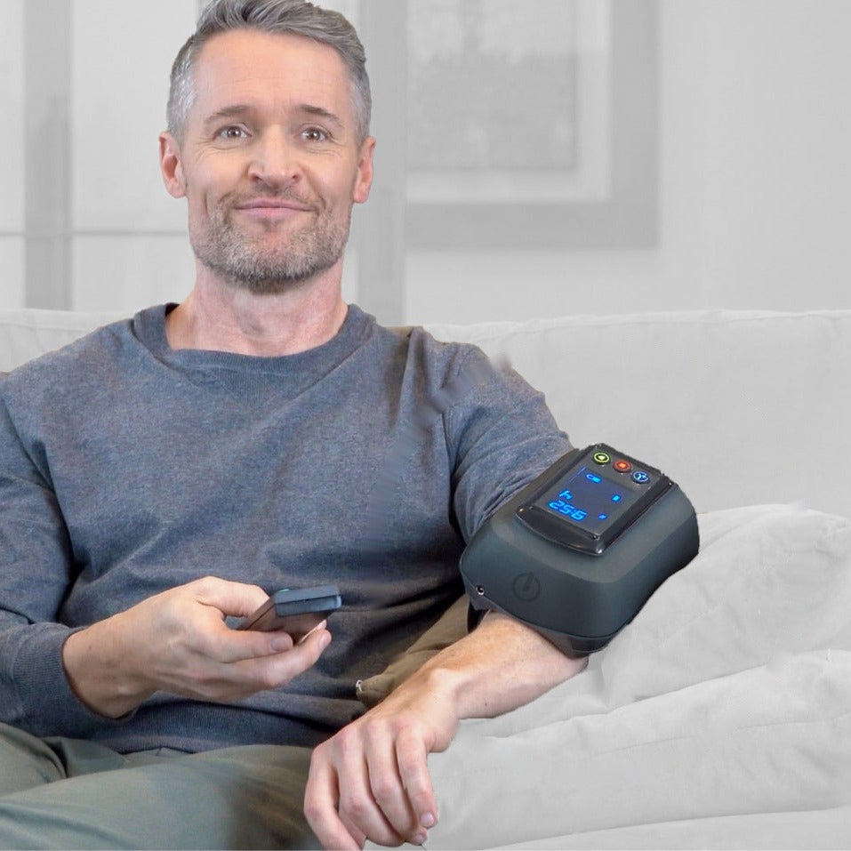 Man relaxing on the couch while the Fiix Elbow treats his forearm